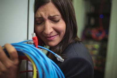 Sad technician leaning on wall in server room